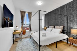 蒙特利尔Deluxe Suites Downtown Montreal的卧室配有一张白色大床和一张书桌
