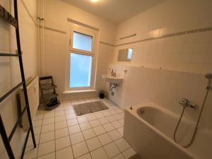柏林Osthafen III的白色的浴室设有浴缸和窗户。