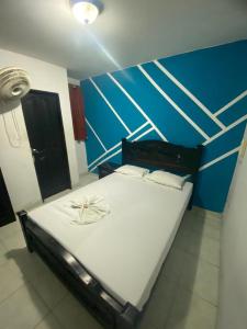 巴兰基亚Residencias Piscis的一张大床,位于一个蓝色的墙壁内
