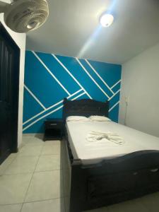 巴兰基亚Residencias Piscis的蓝色墙壁间的一张床位