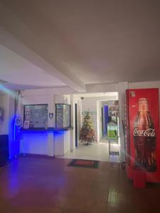 巴兰基亚Residencias Piscis的一间设有古柯苏打水机和圣诞树的房间