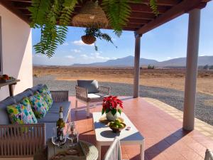 Valles de OrtegaTranquila casa rural en el centro de Fuerteventura的天井配有沙发、桌子和椅子