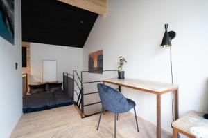 托尔斯港Lonin - Brand New Premium Apartment in the heart of Tórshavn的客房设有书桌、椅子和壁炉。