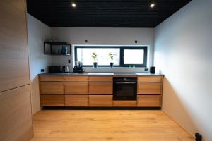 托尔斯港Lonin - Brand New Premium Apartment in the heart of Tórshavn的厨房配有木制橱柜和窗户。