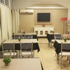 胡宁Hotel Azul Junin的用餐室配有桌椅和平面电视。
