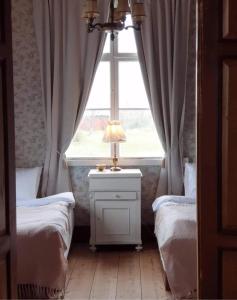 HemseRonehamn Bed and Breakfast的一间卧室设有两张单人床和一个窗户。