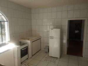 库里提巴Hospedagem com carinho!的白色的厨房配有冰箱和炉灶。