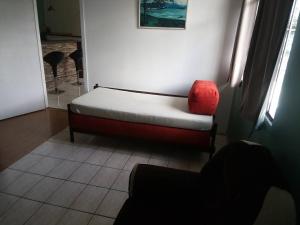 库里提巴Hospedagem com carinho!的配有床和红色椅子的房间