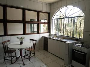 库里提巴Hospedagem com carinho!的厨房配有桌椅和窗户。