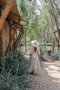 KoondrookKoondrook Glamping Retreat的戴帽子的女孩沿着土路走