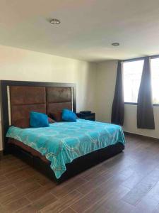 底拉斯卡拉PRECIOSA CASA NUEVA UNA PLANTA NAMASTE的一间卧室配有一张带蓝色床单和蓝色枕头的床。
