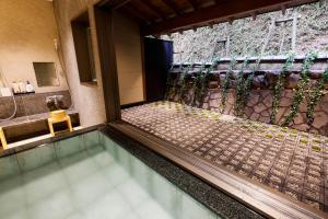 丰冈市汤乐城崎温泉花园旅馆的一座带淋浴的别墅内的游泳池
