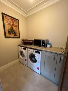 基拉尼No. 8 Ceide Spris Self Catering House的洗衣房配有洗衣机和柜台。