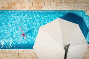 莱特宁岭BIG4 Opal Holiday Park的在带遮阳伞的游泳池中潜水