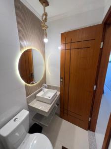 Costa DouradaRecanto Bela Vista II的一间带卫生间、水槽和镜子的浴室