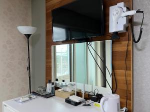 济州市Hill Hotel的梳妆台上方的镜子,电视