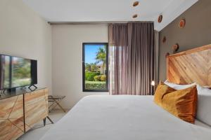 MalmokGold Coast Aruba - Aurum Collection的一间卧室配有一张床和电视