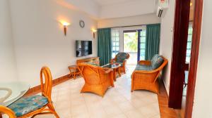 波德申Long Sands Port Dickson的客厅配有桌椅和电视