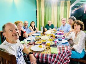 锡吉里亚锡吉里萨曼民宿的一群坐在桌子旁吃食物的人