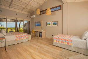 安加罗阿Hotel Ohana Rapa Nui的一间卧室配有两张床、一张桌子和一张书桌