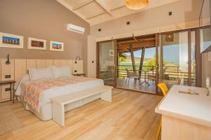 安加罗阿Hotel Ohana Rapa Nui的一间卧室配有一张床,阳台配有桌子