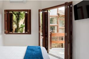 圣保罗Afras Maresias的一间卧室设有一张床和一个滑动玻璃门