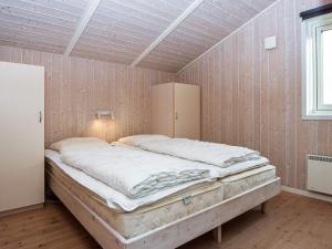 宝可波Holiday Home Hvidbjergvej的一张大床,位于一个墙上的房间