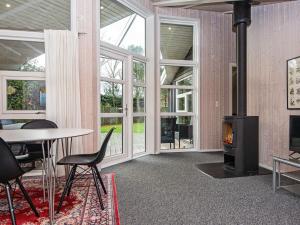 宝可波Holiday Home Hvidbjergvej的客厅设有壁炉、桌子和椅子