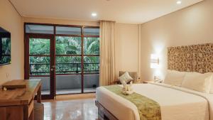 库塔AlamKulkul Boutique Resort的一间卧室配有一张床、一张书桌和一个窗户。