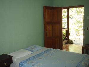 埃尔莱马特Guest house Posada Ixchel的一间卧室设有一张床,并有通往庭院的门