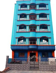迪卡Goroomgo Muskan Guest House Digha的一座高大的蓝色建筑,前面有楼梯