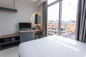 新加坡ibis budget Singapore Gold的卧室设有白色的床和大窗户