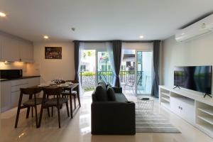 Ban Phlong SawaiMantra Beach condominium M116,M140的带沙发和桌子的客厅以及厨房。