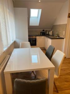 费尔德基希Ferienwohnung Alpina的厨房配有白色的桌椅