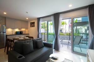 Ban Phlong SawaiMantra Beach condominium M116,M140的客厅以及带沙发和桌子的厨房。