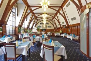 玛丽亚温泉Ensana Hotel Pacifik的一间带桌椅和时钟的餐厅