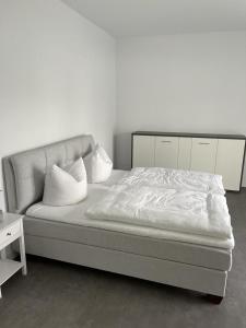 舍纳贝克Ferienhof Elbaue的一张带白色床单和枕头的床