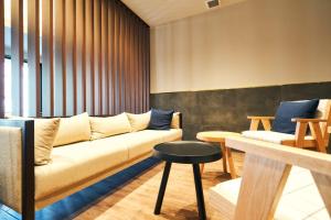 北九州Rakuten STAY Kokura Station Family Room的带沙发和凳子的客厅