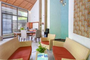 美娜多Thalassa Dive & Wellbeing Resort Manado的一间带椅子和桌子的用餐室