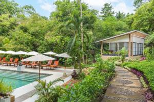 美娜多Thalassa Dive & Wellbeing Resort Manado的一座带游泳池和度假村的别墅