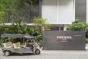 曼谷曼谷宾乐雅服务公寓的坐在大楼前的高尔夫球车上的人