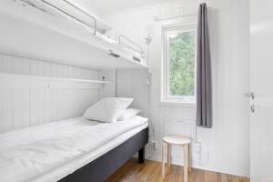 于默奥First Camp Nydala-Umeå的一间带床和凳子的小卧室