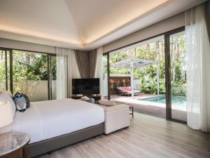 蔻立Avani Plus Khao Lak Resort的卧室设有一张白色大床和一个游泳池
