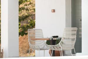 斯基罗斯岛Villa Lino的门廊上配有两把白色椅子和一张桌子