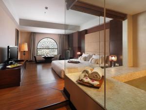 棉兰Grand City Hall Hotel & Serviced Residences的大型酒店客房设有床和电视。