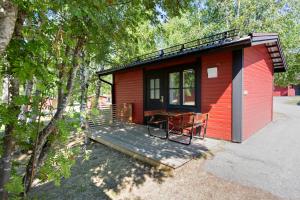 于默奥First Camp Nydala-Umeå的红色小屋,甲板上配有桌椅