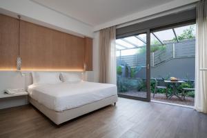 雅典Athens Hill Luxury Apartments的卧室设有白色的床和大窗户