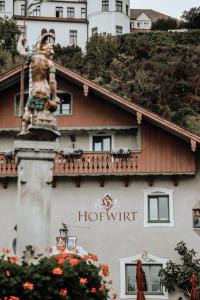 诺伊博伊埃尔恩Hotel Hofwirt Neubeuern的酒店前方有雕像的建筑