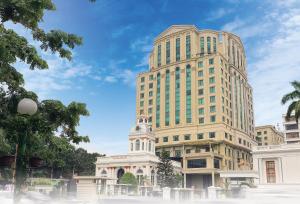 棉兰Grand City Hall Hotel & Serviced Residences的一座高大的建筑,前面有一个钟楼