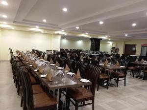 KatraHotel Sravasti Residency的大型用餐室配有桌椅